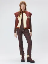 Chaleco de corte cuadrado con diseño bicolor en tonos terracota y crema. Presenta cierre frontal metalizado, parches de nylon en el pecho, interior forrado en corderito y cordón ajustable en el ruedo.