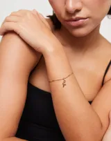 Pulsera dorada con eslabones formados por bolitas y piezas alargadas.