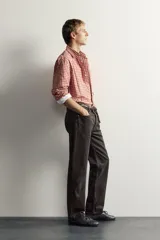 Jeans straight fit de corte recto y tiro medio, confeccionados en denim de algodón con efecto lavado en color marrón oscuro, con diseño clásico de cinco bolsillos y cierre frontal con botonadura.