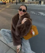 Chaqueta corta de pelo sintético color marrón, con cuello amplio y mangas abullonadas.