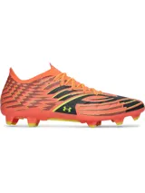 Championes de futbol Under Armour Shadow Pro 4 FG, diseño en color anaranjado con patrones geométricos en negro y amarillo. Cuentan con empeine textil ligero, cuello de punto tipo calcetín, cordones frontales y suela con tacos moldeados para césped natural.