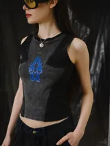 Musculosa entallada de tejido de punto con efecto lavado en tonos negro y gris, sin mangas y corte al cuerpo. Cuenta con un diseño de recortes estructurados y un estampado frontal en azul.