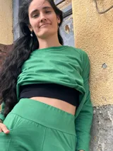 Pantalón tipo palazzo de tiro alto, confeccionado en jersey de algodón color verde. Presenta un diseño amplio con bolsillos laterales y una faja ancha en la cintura que proporciona ajuste y soporte.