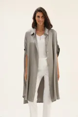 Vestido camisero largo color gris, de seda lisa, con cuello camisero, manga corta y cierre frontal con botones.