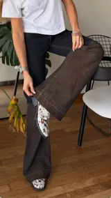 Pantalón de jean de tiro medio con diseño bicolor, combinando un tono azul oscuro en la parte superior y un tono más claro en la parte inferior. Presenta una cintura con detalle de textura tipo animal print y costuras reforzadas en las rodillas.