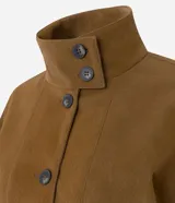 Campera de poliuretano texturizado color marrón, con cuello alto, cierre frontal con botones, mangas largas con puños elásticos y ruedo con elástico.