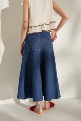 Falda larga de jean color marrón, de corte acampanado con costuras pespuntadas visibles y diseño de tiro medio.