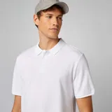 Remera polo blanca de piqué de algodón con cuello clásico y tapeta de tres botones. Corte recto y mangas cortas con ribete.