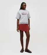 Short pollera corta color rojo, confeccionada en viscosa certificada. Posee un canesú asimétrico en la cintura que crea un efecto traspasado en la parte delantera. Incluye un bolsillo discreto y tiene un acabado limpio en los bordes.