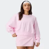 Buzo rosado con hombros caídos, cuello redondo y diseño holgado, confeccionado en suave felpa.