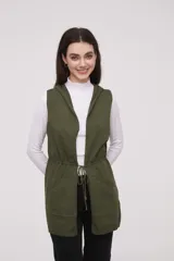 Chaleco largo sin mangas de tejido de punto color negro, con capucha y lazo ajustable en la cintura. Presenta bolsillos frontales y diseño abierto.