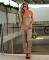Pantalón de vestir color beige con estampado a cuadros, corte recto y cierre frontal con botón y cremallera.