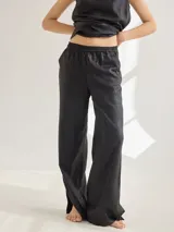 Pantalon de corte recto y tiro medio, confeccionado en lino, con cintura elastizada y tajos laterales en el ruedo.