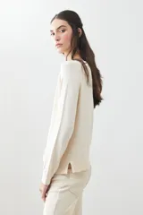 Sweater básico de tejido de punto color beige, de corte recto y mangas largas.