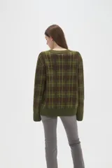 Cardigan de punto con diseño de cuadros, cuello en V y cierre frontal con botones. Presenta un corte holgado y mangas largas.