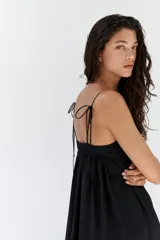 Vestido midi negro de mezcla de viscosa, con escote cuadrado y breteles finos dobles con detalle de moña. Canesú ajustado con parte posterior de punto smock y falda fruncida con volumen.