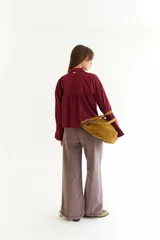 Camisa de corte boxy en color blanco, con cuello clásico, cierre frontal de botones y mangas largas con puños estructurados con tablas. Presenta costuras a contratono y detalle de frunce en la espalda.