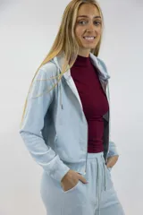Campera de felpa celeste con capucha, cierre frontal completo y bolsillos tipo canguro.