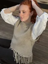 Chaleco tejido a mano color beige con cuello alto y flecos en el ruedo. Hecho por encargo en lana.