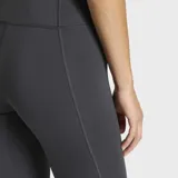Calza deportiva Adidas de pretina alta, color gris oscuro, con logo de la marca estampado en blanco en el muslo izquierdo. Confeccionada con tecnología AEROREADY para absorción de humedad y diseño de costuras reducidas para mayor comodidad.