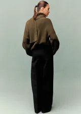 Pantalón de vestir negro de corte recto y largo, con detalle de pliegues frontales, dos bolsillos laterales y cierre de cremallera.