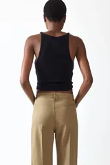 Pantalón tobillero de corte bootcut en lona de algodón, color marrón, con cintura estándar, bolsillos delanteros y pliegues marcados.