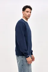 Buzo de cuello redondo en felpa con friza, color azul marino con detalle de cuello en color crema. Presenta bordado de la marca en el pecho y en el puño de la manga.