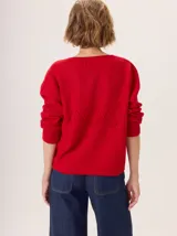 Buzo de lana color marrón topo, con cuello en V y diseño de punto calado en rombos en el frente y mangas.