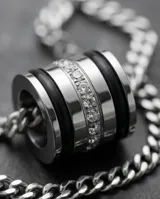 Collar de acero con cadena de eslabones finos y dije cilíndrico decorado con circonias incrustadas.
