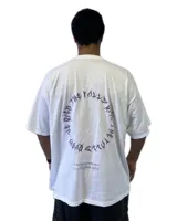 Remera blanca de corte holgado con estampado circular en la espalda con texto en color violeta.