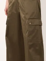 Pantalón cargo de satén color verde oliva, con bolsillos laterales con solapa y broches metálicos.