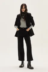 Polera de manga larga con cuello alto, confeccionada en tejido de punto acanalado con diseño de rayas horizontales en color marrón y turquesa. Presenta un bordado pequeño en el pecho y un calce ajustado al cuerpo.