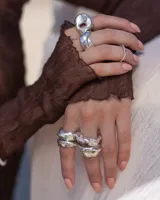 Anillo de plata 925 con diseño irregular y superficie texturizada. Presenta un orificio circular en la parte superior. Talle estándar N 15 (17 a 18 mm de diámetro).