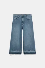 Bermuda larga de jean color azul, tiro medio, con diseño wide leg y bolsillos. Cuenta con bajo desflecado y cierre frontal con cremallera y botón metálico.