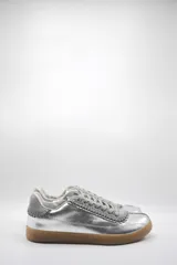 Zapatillas bajas de cuero color crema con detalles en marrón y cordones blancos.