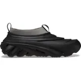 Zueco negro con cuello de lycra gris, suela de goma con diseño ondulado y orificios de ventilación.
