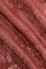 Minifalda pareo corta de encaje color marrón con diseño floral translúcido, borde inferior festoneado y tiras finas para anudar en un lateral.