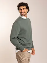 Sweater azul de tejido de punto con cuello redondo y logo bordado en el pecho.