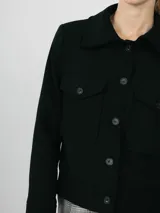 Campera verde militar de pana con cuello camisero, cierre frontal con botones a tono, dos bolsillos de parche con solapa en el pecho y corte cropped.