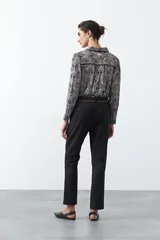 Pantalón de vestir negro de corte recto, con cintura estructurada y costura central vertical en las piernas que aporta un acabado sastrero.