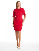 Vestido de crepe marca Emma & Michele, color rojo, con cuello a la base y detalle de escote entrelazado. Presenta mangas cortas, cierre invisible en la espalda y tajo en el ruedo.