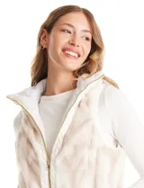 Chaleco reversible marca Weekend Routine, con un lado de piel sintética suave en tonos beige y blanco, y el otro lado capitoneado en blanco con diseño de rombos. Cuenta con cuello alto, bolsillos delanteros y cierre metálico dorado.