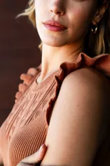 Vestido tejido color marrón, marca Absolutely Famous. Presenta diseño calado en la parte delantera y volados en las sisas.