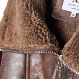 Campera tipo aviador de cuero sintético marrón con interior y detalles en corderito sintético al tono. Presenta cierre frontal, cuello solapa amplio y puños con borde de corderito.