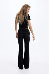 Pantalón tipo legging acampanado de punto acanalado fino, con cintura plegable y laterales fruncidos que generan un efecto drapeado.