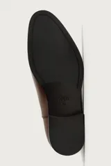 Bota Chelsea de hombre en color marrón oscuro, con diseño liso, punta afilada, elásticos laterales y tirador trasero.