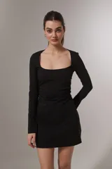 Vestido corto negro de mangas largas con escote cuadrado y frunce lateral.