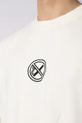 Remera de corte oversize confeccionada en algodón premium de alto gramaje. Presenta un diseño minimalista con un pequeño logo bordado en el centro del pecho y un parche estampado en la espalda. Posee cuello redondo y mangas cortas con caída relajada.