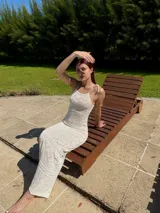 Vestido largo de tejido calado color blanco, con breteles finos y corte ajustado.