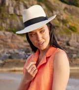 Sombrero tipo Panamá de paja color natural, con cinta negra alrededor de la copa.